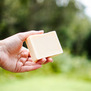 savon en barre la fileuse savonnerie des diligences lait de chèvre et amande amère 100g dans une main